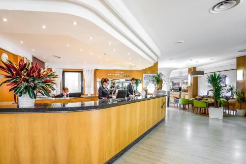 a lobby of a hotel with people sitting at a counter at Hotel Bologna Airport in Bologna