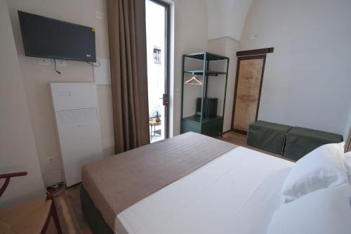 a bedroom with a bed and a tv on the wall at B&B Le volte leccesi in Porto Cesareo