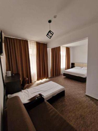 a hotel room with two beds and a couch at Virginia Mamaia-Nord in Mamaia Sat/Năvodari