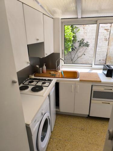 Il comprend une petite cuisine équipée d'une cuisinière et d'un évier. dans l'établissement Large two-room apartment with garden, à Courbevoie