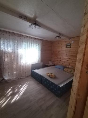 a bedroom with a large bed in a wooden room at Shambhala, eko selo Blatuša in Gvozd