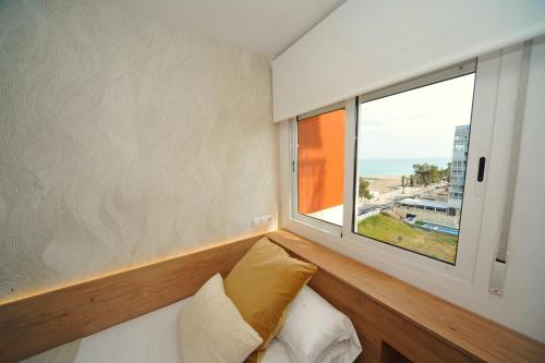 una camera da letto con finestra e un letto con cuscini di ESTORIL Vista Mar Premium Special a Benicàssim