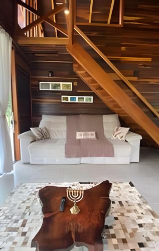 a bedroom with a white bed with wooden stairs at ASA | Refúgio Vitória | Cabana de luxo | Jacuzzi in Ibirama