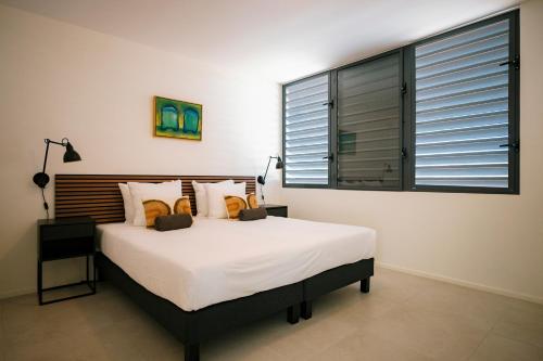 a bedroom with a large bed and a large window at Blue Bay Curaçao Golf & Beach Resort in Willemstad