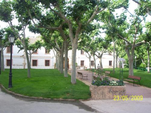 a park with benches and trees and a building at Hotel Balneario de la Concepción in Villatoya