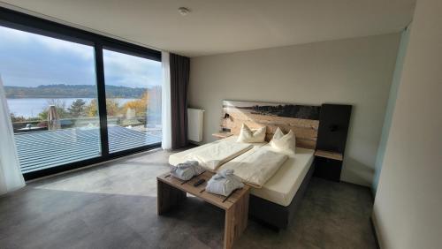 a large bedroom with a bed and a large window at Hochwälder Wohlfühlhotel in Losheim