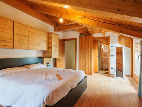 a bedroom with a large bed with wooden walls at Apartment Erika by Interhome in Canazei