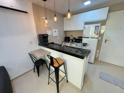 a kitchen with a counter and a table and chairs at Ap próx ao Shopping com garagem, piscina e ar in Sobral