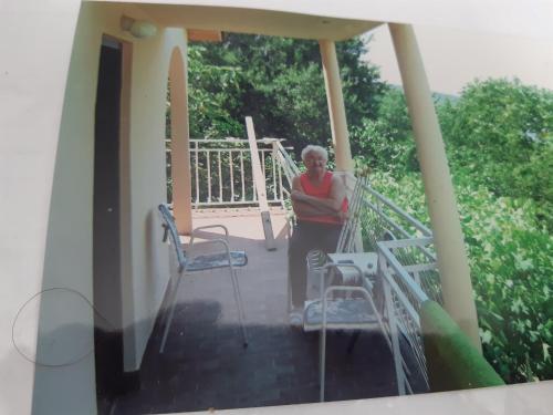 a woman standing on the porch of a house at Kruce accommodation in Ulcinj