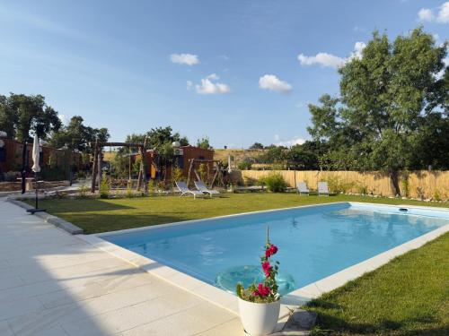 a swimming pool in a yard with a playground at Retiro da Vila in Sendim