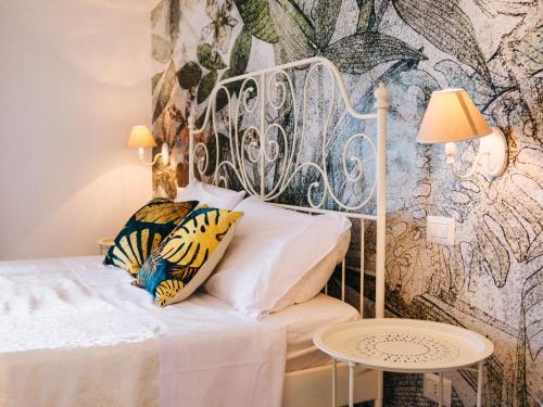 een slaapkamer met een wit bed met bloemenbehang bij Apartment Crystal Sea Apartment by Interhome in Santa Maria Navarrese