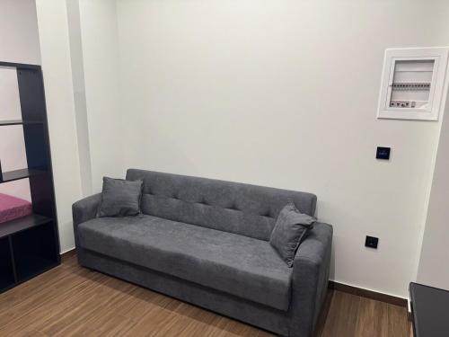 a gray couch in a room with a white wall at RAMhouse I in Arta