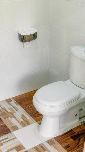 a bathroom with a white toilet in a room at Kampung Nature Stilt House with Paddy Field View in Balik Pulau