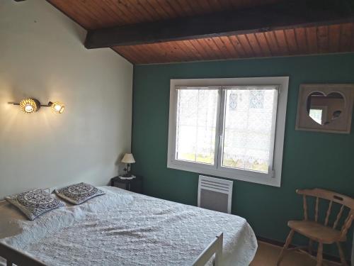 une chambre verte avec un lit et une fenêtre dans l'établissement La Villa, à La Tranche-sur-Mer