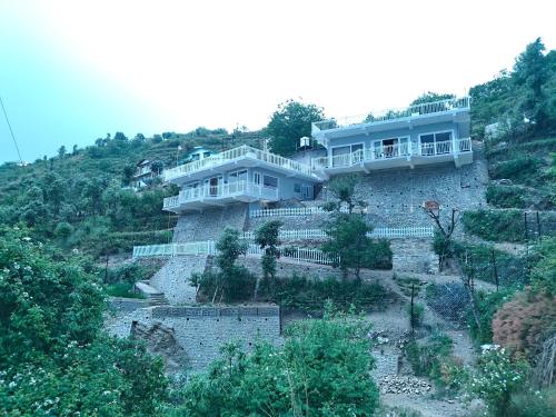 ein Haus an der Seite eines Berges in der Unterkunft Iris Grove in Mukteswar