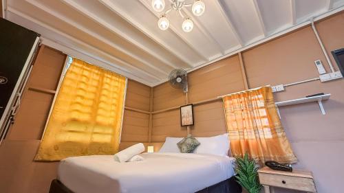 two beds in a small room with a window at Kampung Nature Stilt House with Paddy Field View in Balik Pulau