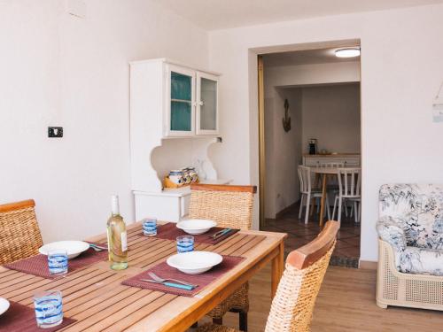 een houten tafel met stoelen en een eetkamer bij Apartment Rosa Dei Venti by Interhome in Santa Maria Navarrese