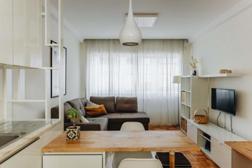 a living room with a couch and a table at Cozy 1-Bedroom with Private Terrace in Palmela in Porto