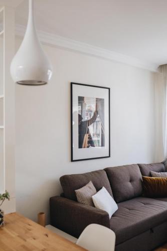 a living room with a couch and a picture on the wall at Cozy 1-Bedroom with Private Terrace in Palmela in Porto