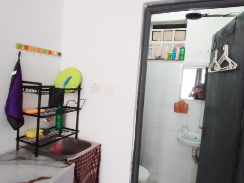 a bathroom with a mirror and a sink and a toilet at Kahawa Wendani Maguna's Supermarket Apartments in Nairobi