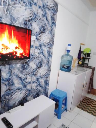 a living room with a fireplace and a tv on a wall at Kahawa Wendani Maguna's Supermarket Apartments in Nairobi