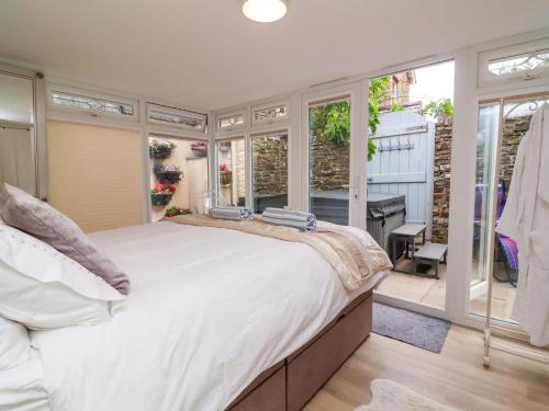 ビデフォードにあるSea Sanctuaryの大きな白いベッドと窓のある寝室