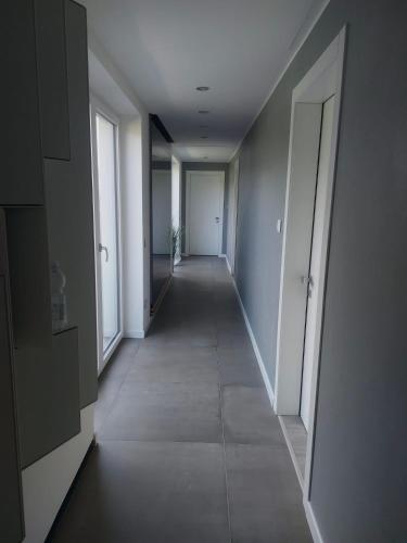 a long hallway with white walls and a hallway with doors at Affittacamere Zafferano in Belluno