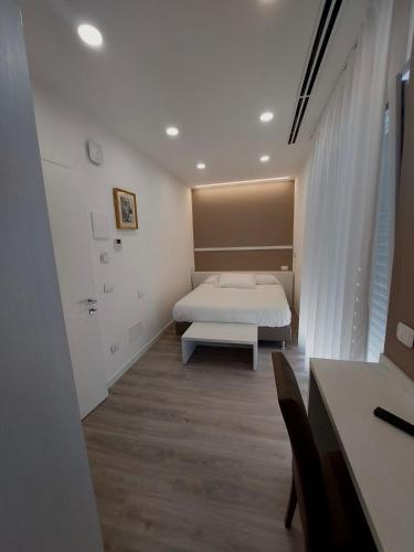 a bedroom with a bed and a table and a desk at Affittacamere Zafferano in Belluno