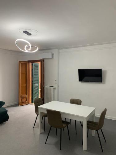 a white dining room with a white table and chairs at Volver Apartment in Margherita di Savoia