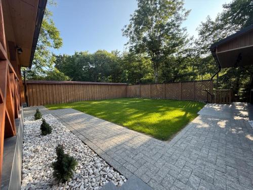 a backyard with a fence and a lawn at Euro Resort in Chynadiyovo
