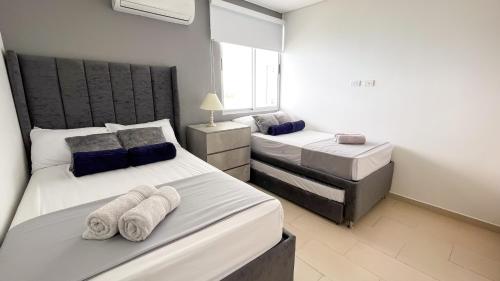 a bedroom with two beds with towels on them at Magico PentHouse Duplex Frente al Mar 3 Habs FB112 in Coveñas