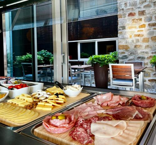 a buffet with meats and cheese on a table at VENEZIANA Boutique Hotel Superior in Koper