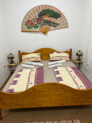 1 dormitorio con 1 cama de madera y 2 almohadas en Sobe Koste, en Subotica