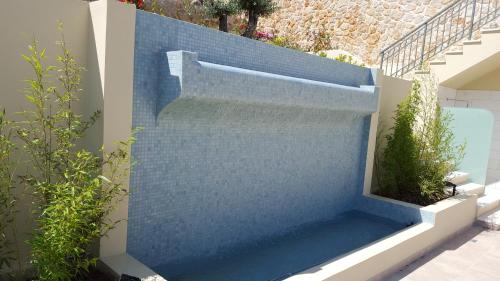 a blue wall with a staircase in a yard at Ionian Vista Villas in Argostoli