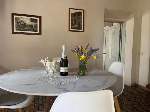 a dining room table with a bottle of wine and flowers at Il Fiorino di Badia in Badia A Passignano