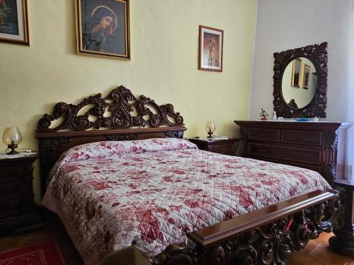 a bedroom with a large bed and a mirror at Domo Pittalis in Pozzomaggiore
