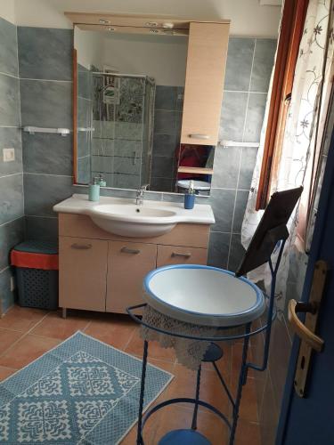 a bathroom with a sink and a table and a mirror at Domo Pittalis in Pozzomaggiore