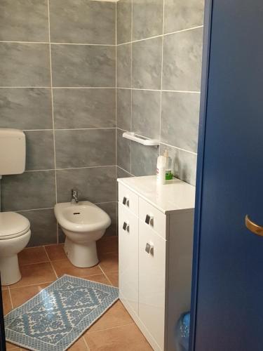 a bathroom with a toilet and a sink at Domo Pittalis in Pozzomaggiore
