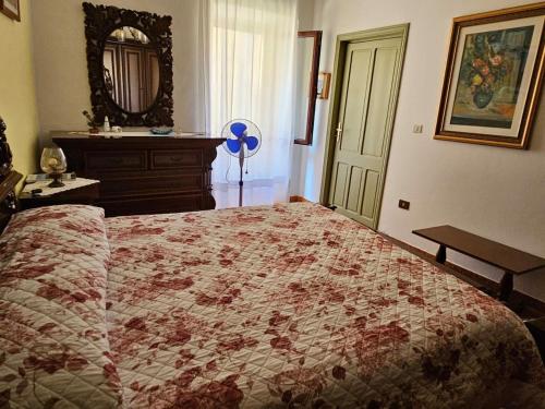 a bedroom with a large bed and a mirror at Domo Pittalis in Pozzomaggiore