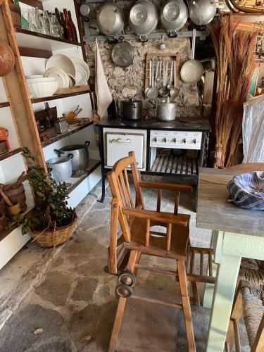a kitchen with a wooden chair in front of a stove at Tra Fiori e Antichità in Cerchiara