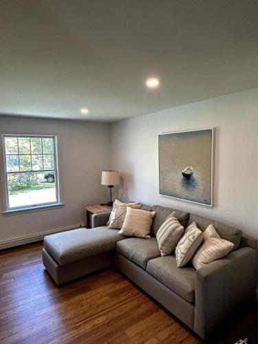 a living room with a couch and a window at House Conveniently Located by Route 1 in Falmouth