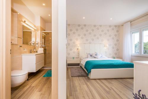 a bedroom with a bed and a bathroom at Apartments & Rooms Milcetic M in Malinska