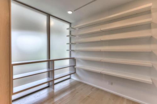 a walk in closet with white shelves and a window at Luxury Hideaway nearly 9000 Sq Ft with Elevator and Huge Deck in Brentwood