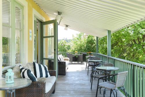 a covered porch with tables and chairs and tables at Maude´s Hotel Enskede Stockholm in Stockholm