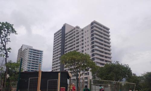 Estrene en Santa Marta vía Barranquilla a 10 minutos aeropuerto, acceso y vista al mar في سانتا مارتا: مبنيين شاهقين في مدينة مع أشخاص أمامهما