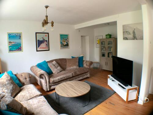 un salon avec deux canapés et une télévision dans l'établissement 3 bed family house with garden in charming estuary village, à Saint-Seurin-dʼUzet