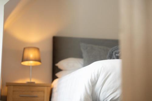 a bedroom with a bed with a lamp on a night stand at Tigh Na Cille Studio in Taynuilt
