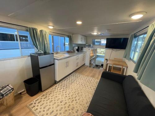 a kitchen and a living room with a couch in a caravan at The Albatross-Houseboat DT Knox in Knoxville