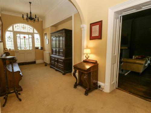 a living room with a lamp on a wooden table at The Retreat at Glanrannell Park House in Llanwrda