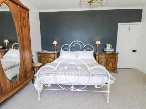 a bedroom with a white bed and a large mirror at The Retreat at Glanrannell Park House in Llanwrda